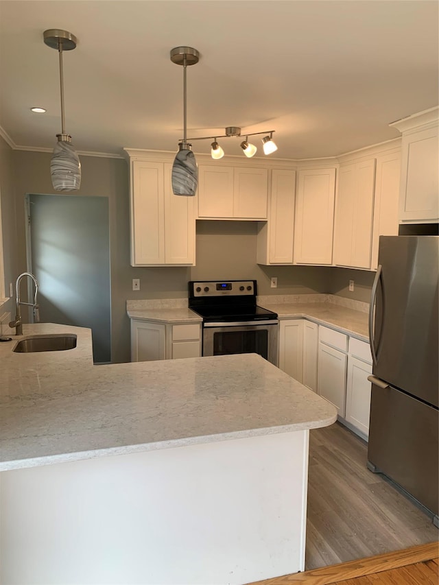 kitchen with light wood-type flooring, ornamental molding, appliances with stainless steel finishes, white cabinets, and a sink