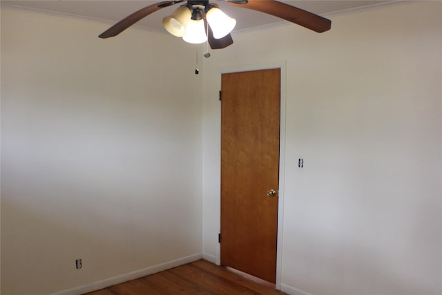 empty room featuring baseboards, wood finished floors, ceiling fan, and ornamental molding