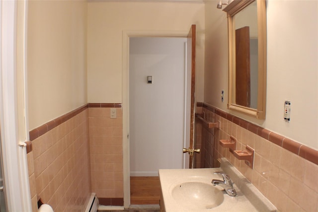 half bathroom with a wainscoted wall, tile walls, and vanity