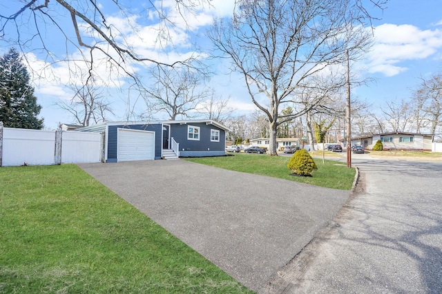 view of front facade with a front yard, fence, driveway, an attached garage, and entry steps