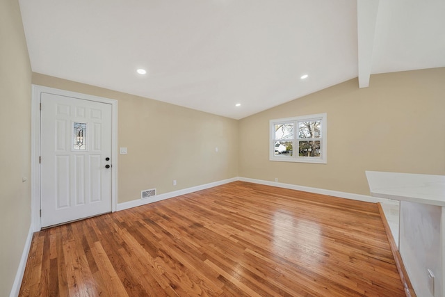 interior space with lofted ceiling with beams, light wood-style flooring, baseboards, and visible vents