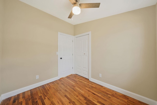 empty room featuring baseboards, ceiling fan, and light wood finished floors