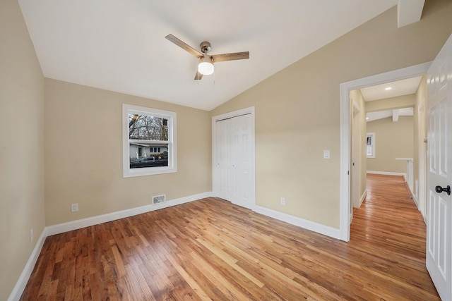 unfurnished bedroom featuring visible vents, baseboards, and vaulted ceiling