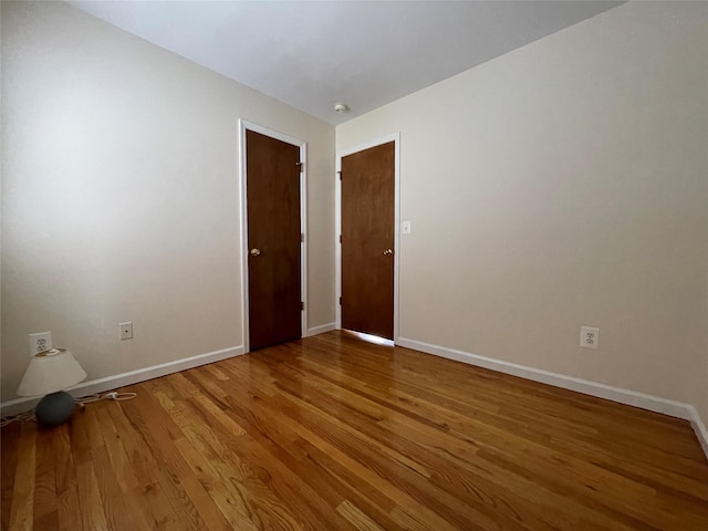 empty room with wood finished floors and baseboards