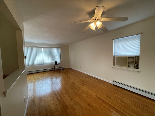 spare room featuring wood finished floors, a ceiling fan, baseboards, and a baseboard radiator