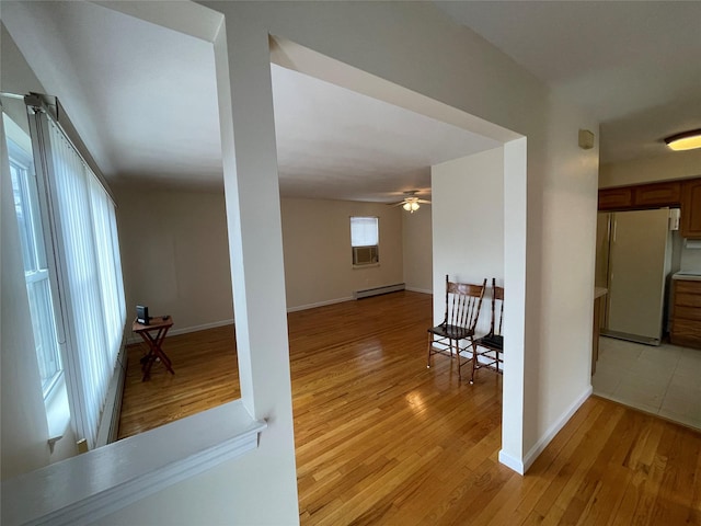 interior space with light wood-style floors, baseboards, and a baseboard radiator