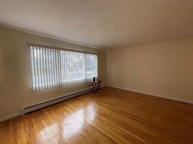 unfurnished room with hardwood / wood-style floors, baseboards, and baseboard heating