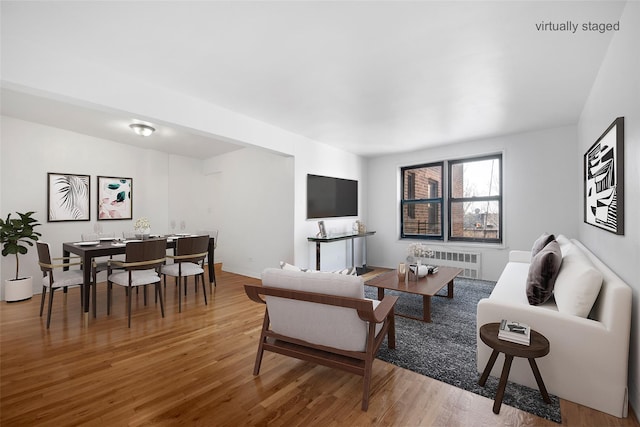 living area with wood finished floors and radiator