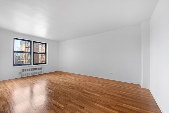 empty room with radiator and wood finished floors