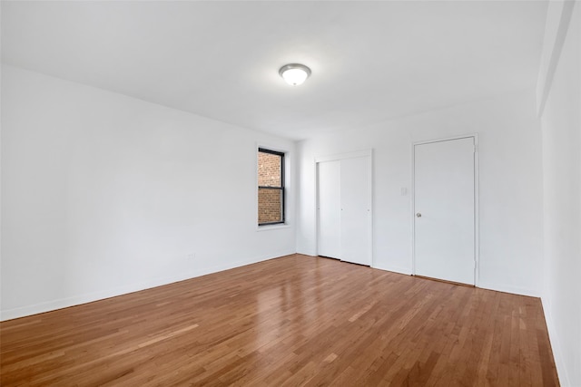 unfurnished bedroom with baseboards and wood finished floors