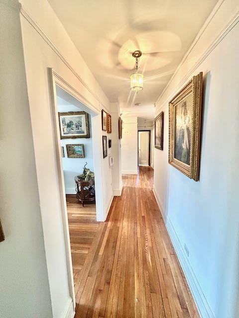 hallway featuring light wood-type flooring and baseboards