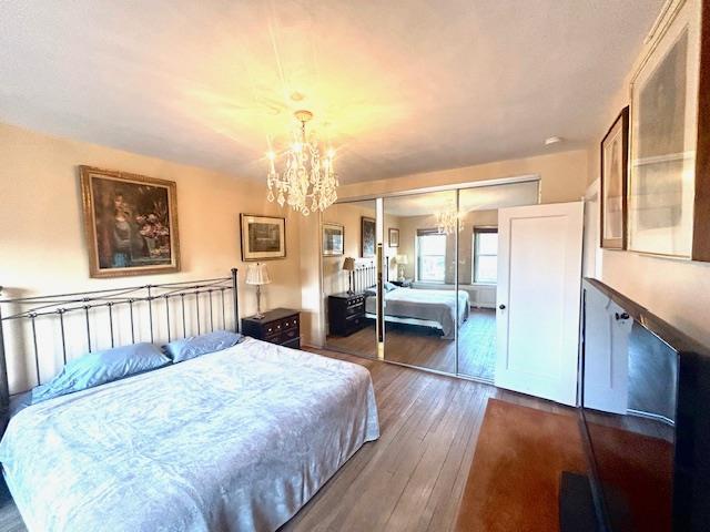 bedroom featuring a chandelier, hardwood / wood-style floors, and a closet