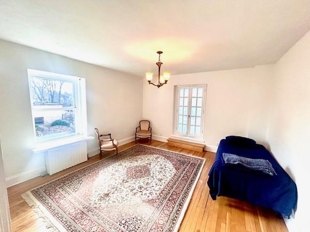 sitting room with a notable chandelier, baseboards, and hardwood / wood-style floors