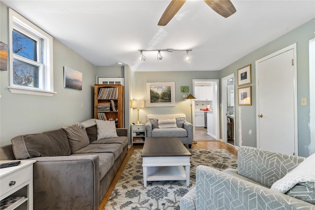 living area with ceiling fan, wood finished floors, and track lighting