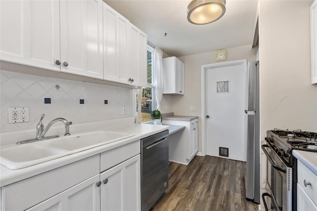 kitchen featuring a sink, stainless steel appliances, white cabinets, decorative backsplash, and dark wood-style flooring