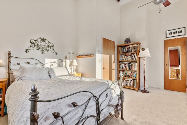 bedroom with baseboards, carpet, a high ceiling, and a ceiling fan