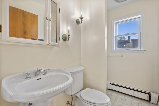 bathroom featuring a sink, baseboard heating, and toilet