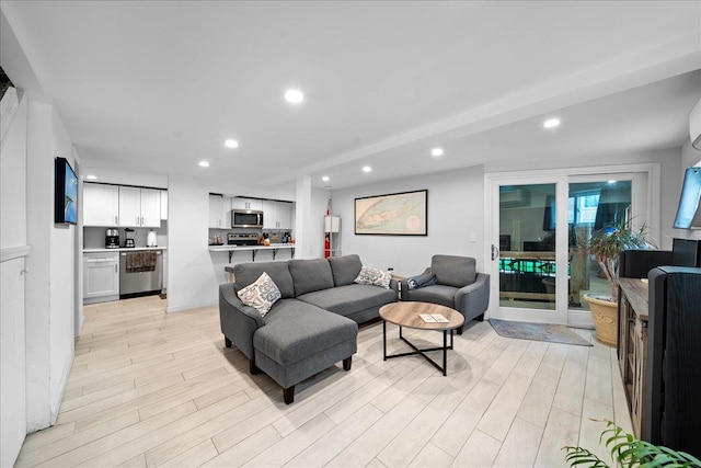 living area with light wood-style floors and recessed lighting