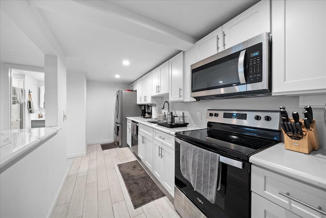 kitchen with white cabinetry, appliances with stainless steel finishes, and a sink