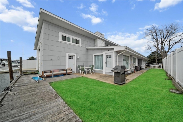 rear view of house with a fenced backyard, outdoor lounge area, a patio, and a yard