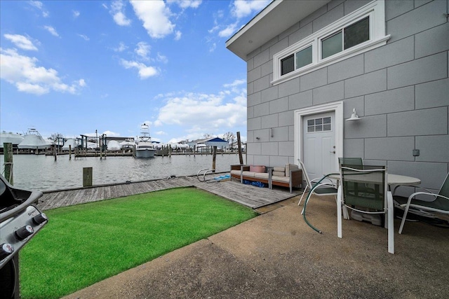 view of yard with a patio area, outdoor lounge area, a dock, and a water view