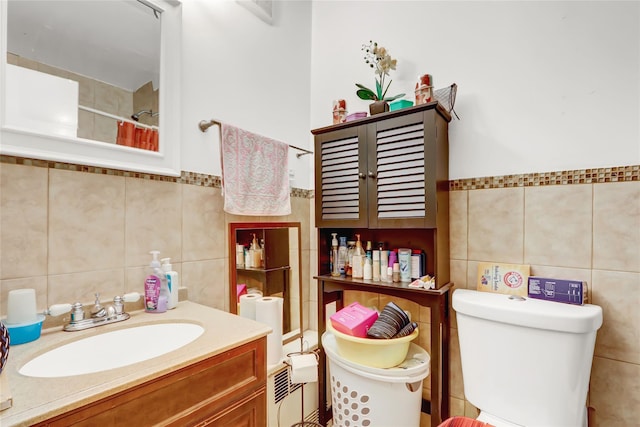 full bath with curtained shower, tile walls, toilet, and vanity