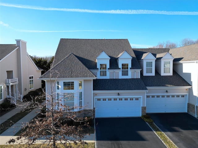 view of front of house featuring aphalt driveway, a garage, and a shingled roof