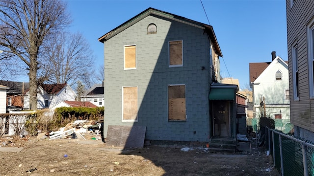 rear view of property with entry steps and fence