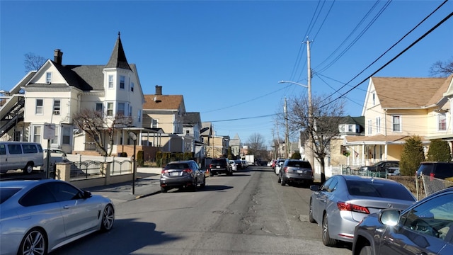 view of road featuring a residential view, street lighting, and sidewalks