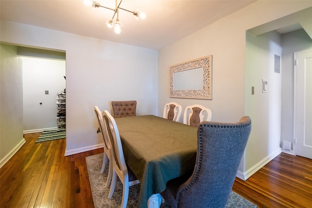 dining room with hardwood / wood-style floors, baseboards, and a chandelier