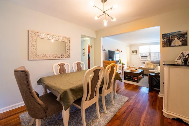 dining area featuring a chandelier, dark wood-type flooring, and baseboards