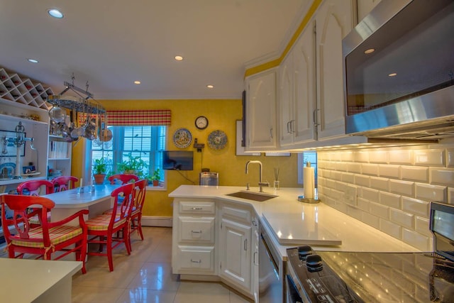 kitchen with a sink, appliances with stainless steel finishes, white cabinets, light countertops, and light tile patterned floors