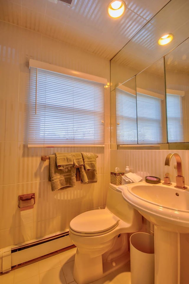 bathroom featuring tile patterned flooring, a baseboard heating unit, toilet, recessed lighting, and tile walls