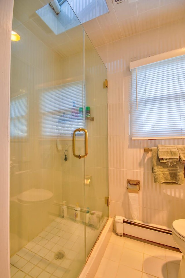 bathroom with tile patterned flooring, a shower stall, toilet, and a baseboard radiator