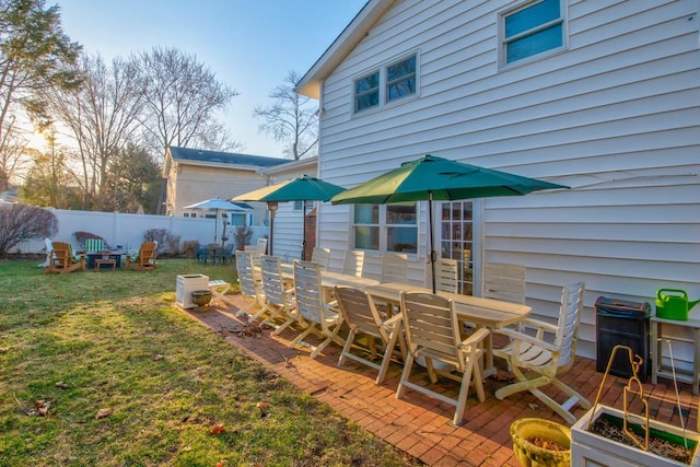 view of yard with a patio area, outdoor dining area, and fence