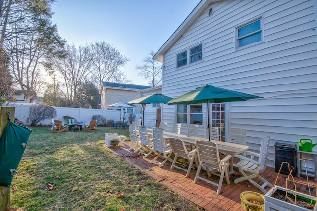 view of yard featuring outdoor dining space, a patio area, and fence