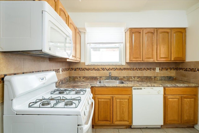 kitchen with brown cabinets, backsplash, light tile patterned flooring, a sink, and white appliances