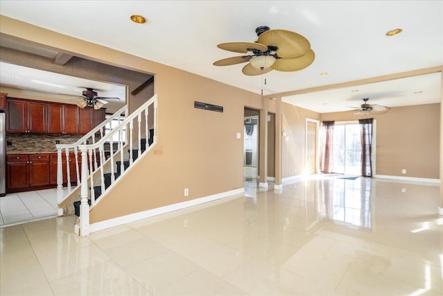 unfurnished room with ceiling fan, stairway, baseboards, and light tile patterned floors