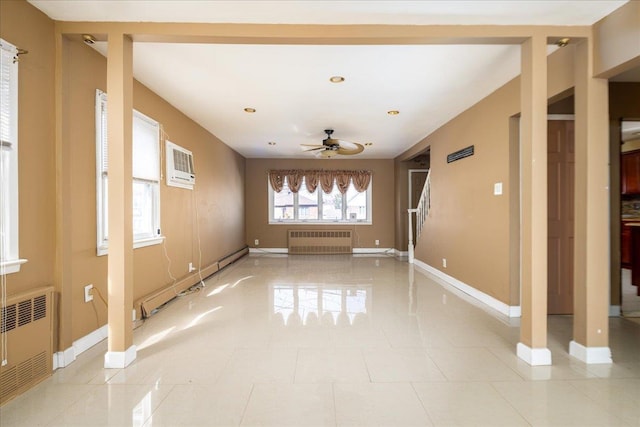 spare room with a baseboard heating unit, radiator, an AC wall unit, and baseboards