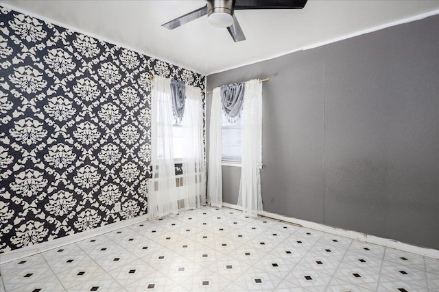 unfurnished room featuring a ceiling fan, baseboards, and tile patterned floors