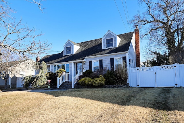 new england style home featuring a chimney, fence, a front yard, and a gate