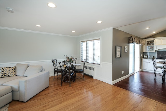 living area featuring ornamental molding, wood finished floors, radiator heating unit, recessed lighting, and wainscoting