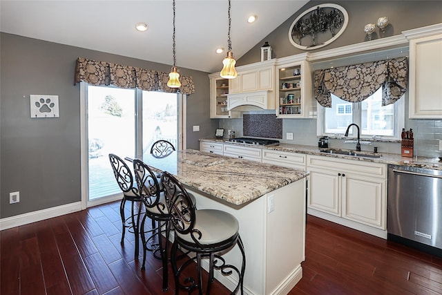 kitchen with a kitchen bar, a sink, dark wood finished floors, light stone countertops, and dishwasher