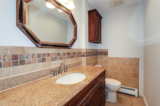 bathroom with visible vents, toilet, tile walls, baseboard heating, and vanity