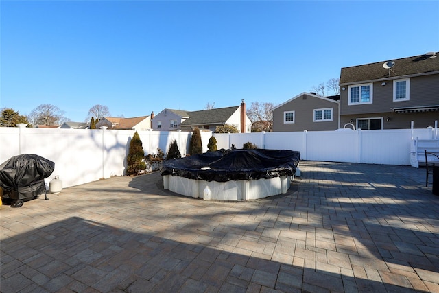 view of patio featuring grilling area, a fenced in pool, and a fenced backyard