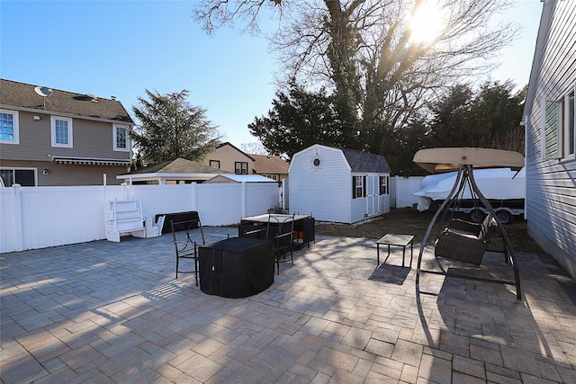 view of patio / terrace featuring a fenced backyard, an outdoor structure, and a shed