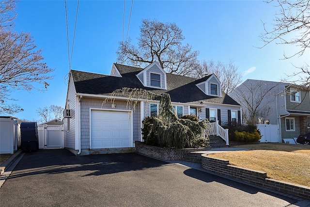 cape cod home with aphalt driveway, fence, a garage, and a gate