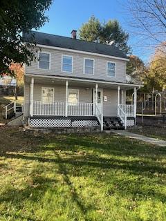 view of front of house with covered porch and a front yard