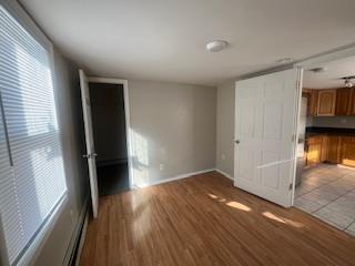 unfurnished bedroom featuring light wood-type flooring and baseboards