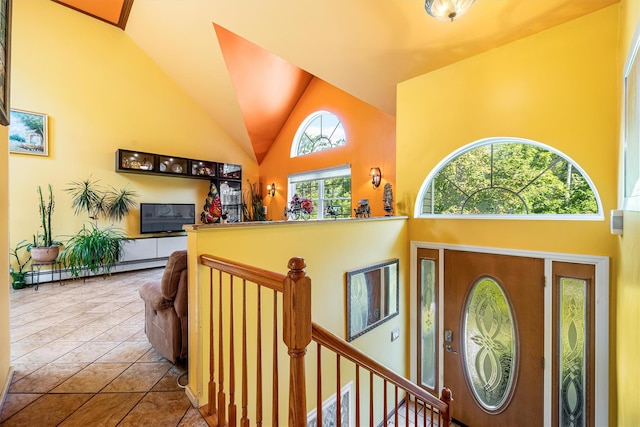 foyer featuring high vaulted ceiling, a baseboard radiator, and tile patterned floors